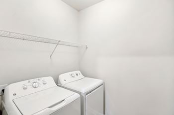 Two white front loading washing machines in a laundry room.